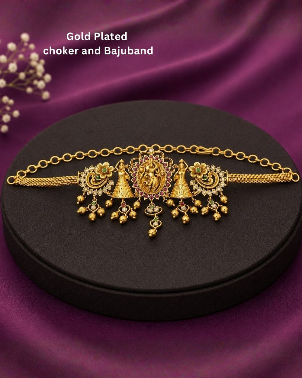 Beautiful gold plated 2-in-1 choker and bajuband set featuring Goddess Lakshmi, peacock and floral motifs embellished with green and pink stones and delicate hanging gold beads. Perfect for weddings, festive occasions, traditional wear, Bharatanatyam styling, parties and gifting.