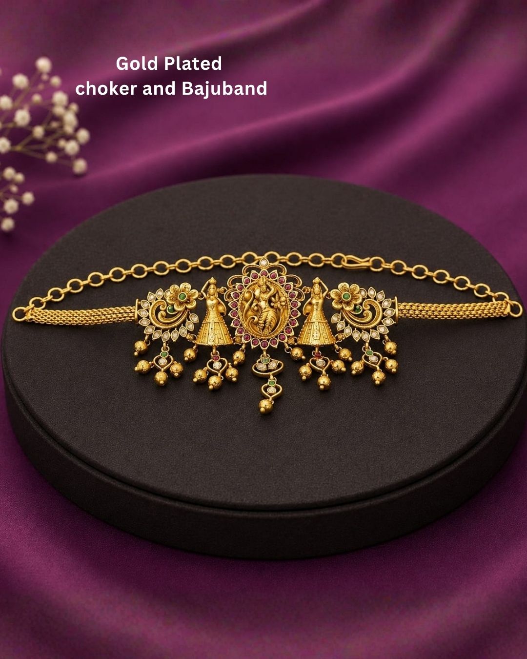 Beautiful gold plated 2-in-1 choker and bajuband set featuring Goddess Lakshmi, peacock and floral motifs embellished with green and pink stones and delicate hanging gold beads. Perfect for weddings, festive occasions, traditional wear, Bharatanatyam styling, parties and gifting.