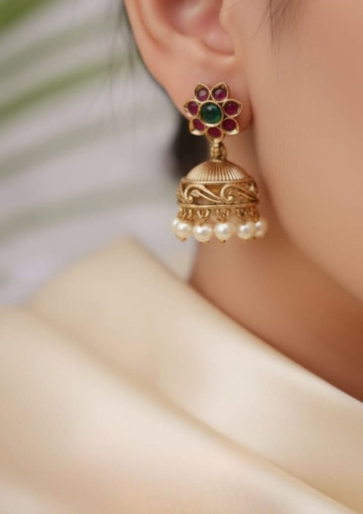 Gold jhumka earring with pearls and gemstones worn by a traditional south indian women looking very shine and very classy and will not fade and can be used for festivals , weedings , functions and can gift 