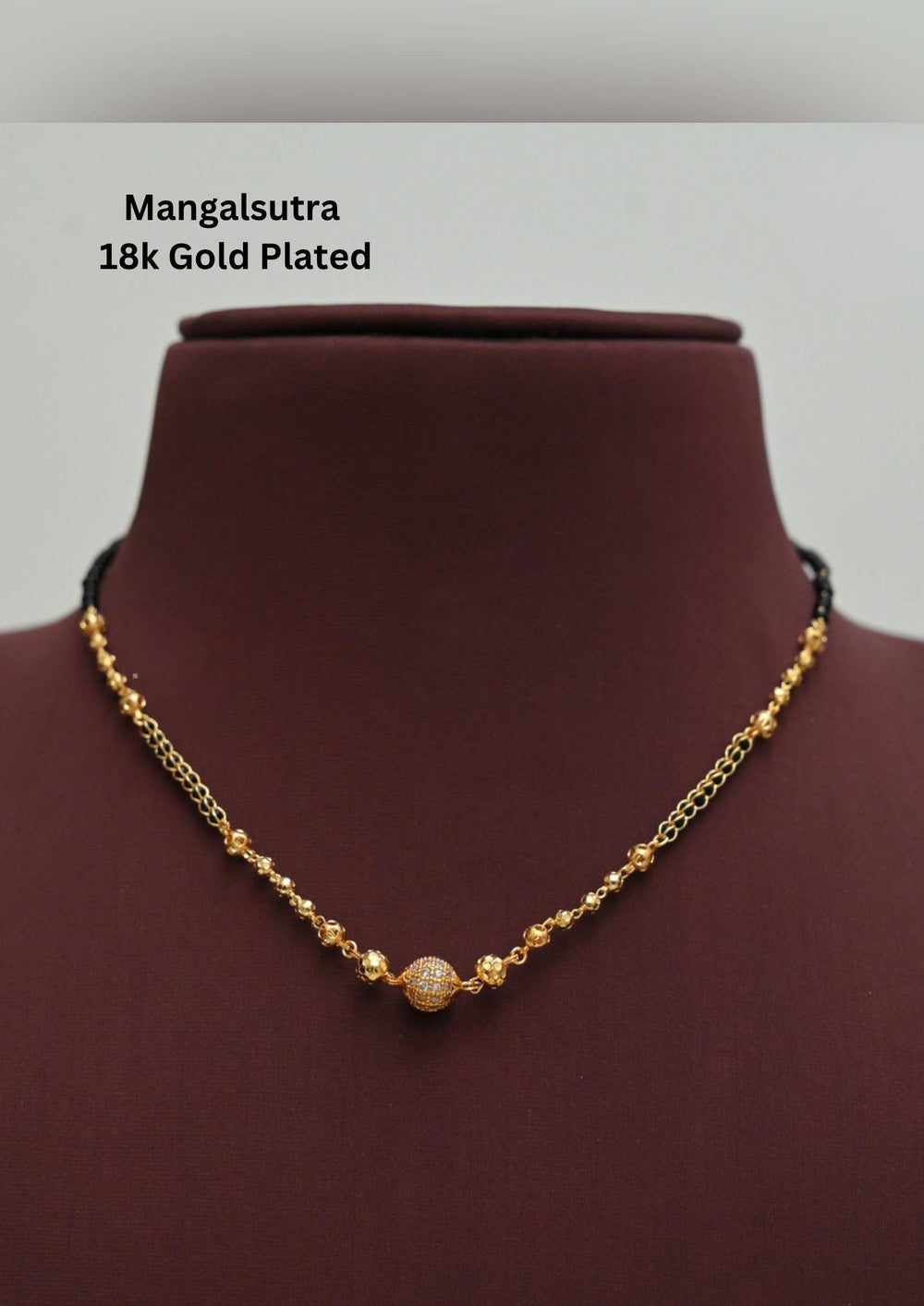 gold plated Ball shape mangalsutra necklace The design features a delicate gold link chain transitioning into sections of traditional small black beads on both sides. The central pendant showcases a sleek, contemporary curved ball shape  and a stylized   . This elegant neckpiece perfect for daily wear, office wear, and casual outfits and weddings , festivals .