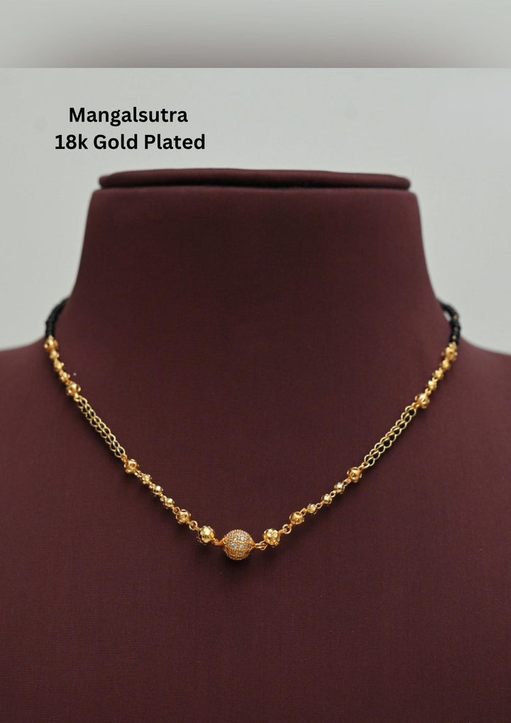 gold plated Ball shape mangalsutra necklace The design features a delicate gold link chain transitioning into sections of traditional small black beads on both sides. The central pendant showcases a sleek, contemporary curved ball shape  and a stylized   . This elegant neckpiece perfect for daily wear, office wear, and casual outfits and weddings , festivals .