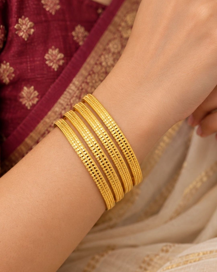 Premium set of four 18K gold plated bangles featuring beautifully engraved geometric patterns.
Designed for lightweight comfort and long-lasting shine.
Perfect for festive celebrations, weddings, office wear, and gifting.