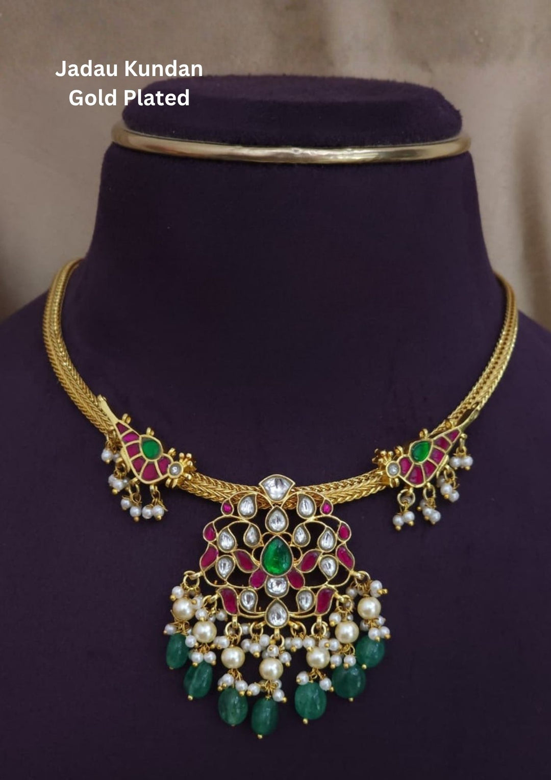 Gold-plated necklace with green and red stones come with jadau kundan in necklace shown 2 peacocks with pearl beads and in pendent shows lotus design and in detailed shown in picture it will not fade color and water proof can used for festivals, bridals, and weeding's  