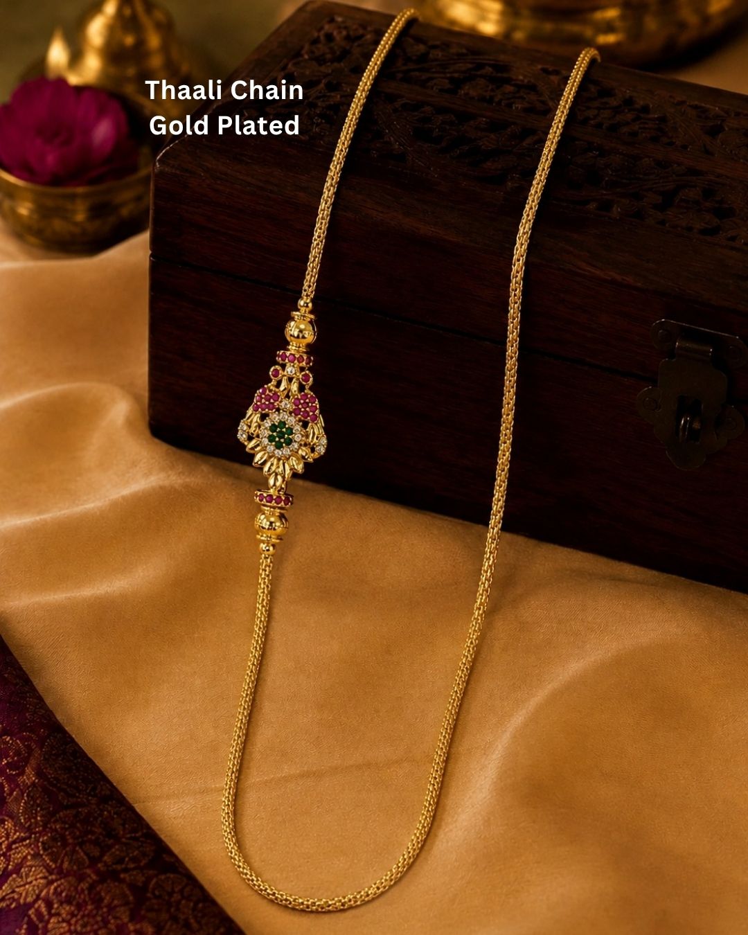 Beautiful gold plated thaali chain featuring a fine textured link chain and an intricate multicolour stone-studded pendant with ruby and green accents. Perfect for weddings, traditional wear, festive occasions, and gifting.