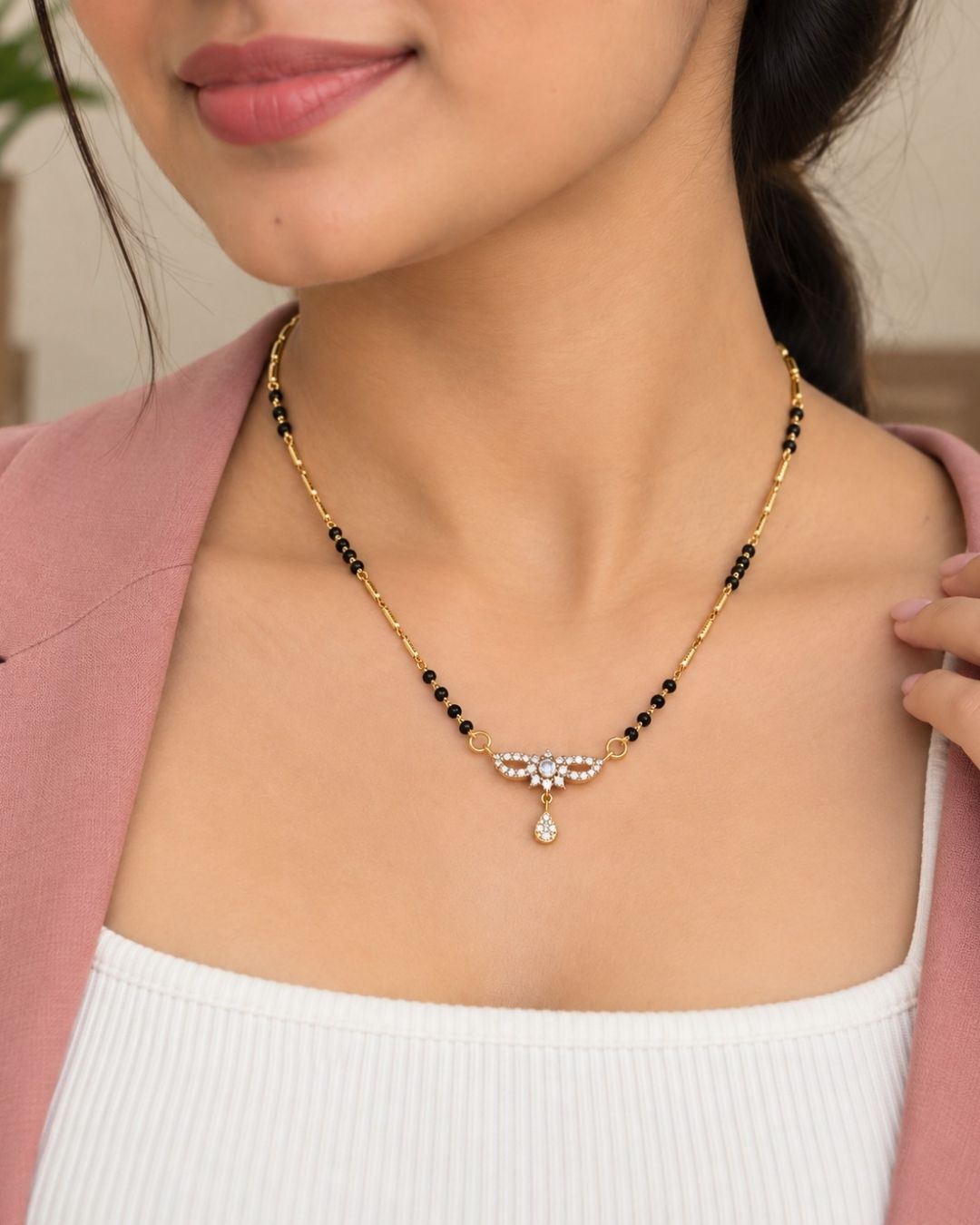 Stylish gold plated mangalsutra featuring black beads, delicate gold detailing, a sparkling CZ pendant, and a teardrop embellishment, perfect for everyday and traditional wear.