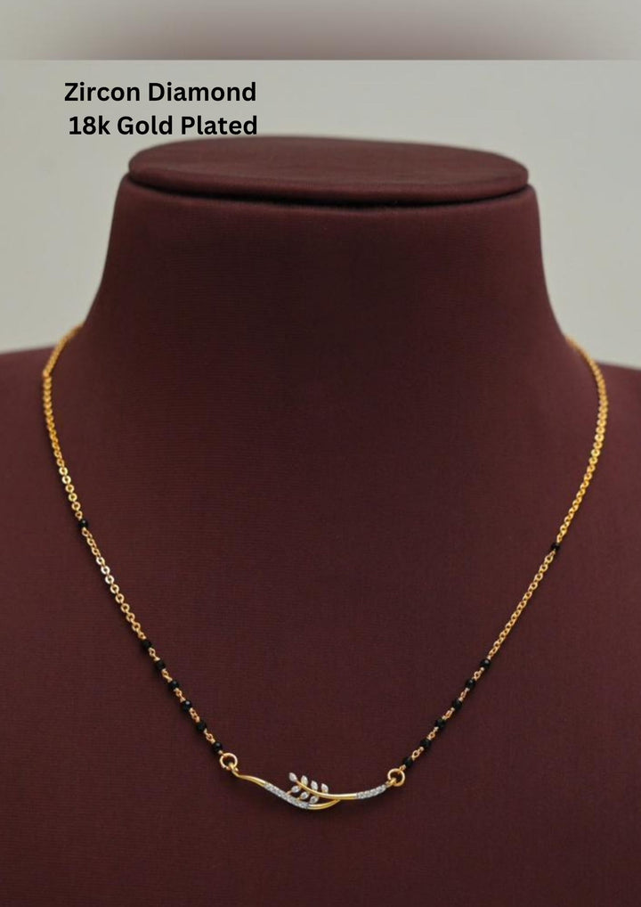 Modern Zircon Diamond gold plated mangalsutra necklace The design features a delicate gold link chain transitioning into sections of traditional small black beads on both sides. The central pendant showcases a sleek, contemporary curved V-shape and a stylized butterfly or floral motif encrusted with sparkling white cubic zirconia stones. This elegant neckpiece perfect for daily wear, office wear, and casual outfits.