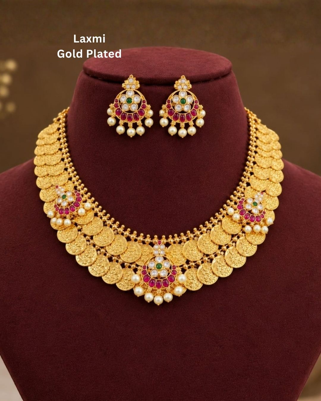 Traditional gold plated designer necklace and earrings set featuring rows of detailed coin motifs, floral designs with ruby, green and white stones, and pearl drops, perfect for festive, wedding, and traditional occasions.