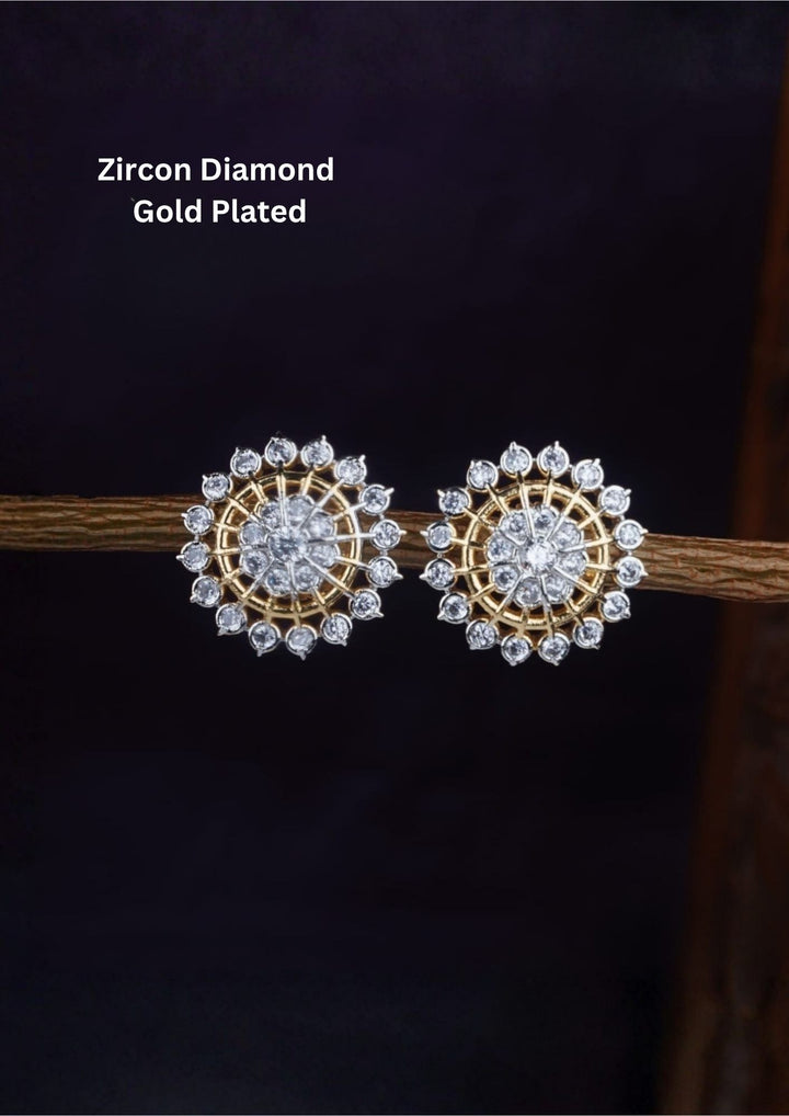 A pair of gold plated openwork round stud earrings designed like a stylized wagon wheel or sunburst. The jewelry features a central cluster of pure Zircon diamonds, connected by slim golden spokes to an outer halo ring entirely lined with matching micro-pave white crystals.
