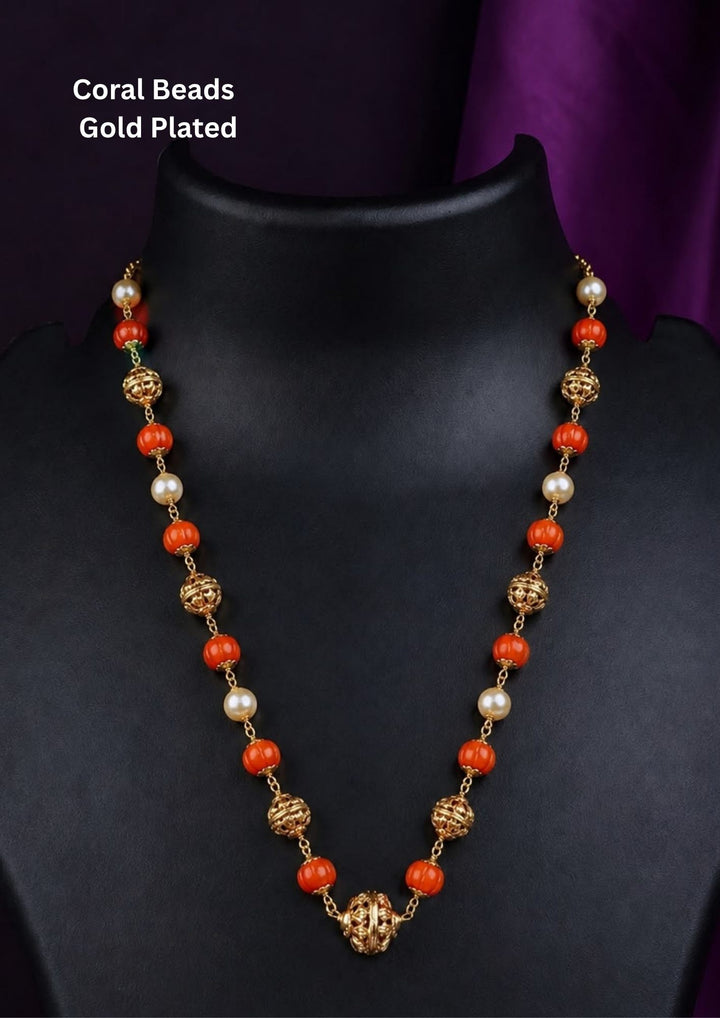 A coral bead and gold-plated beaded necklace Traditional coral gold plated necklace featuring coral stones, pearl stins and gold stones and intricate handcrafted detailing for an elegant festive appearances featuring intricate antique detailing with pearl Perfect for weddings, festivals and ethnic celebrations.