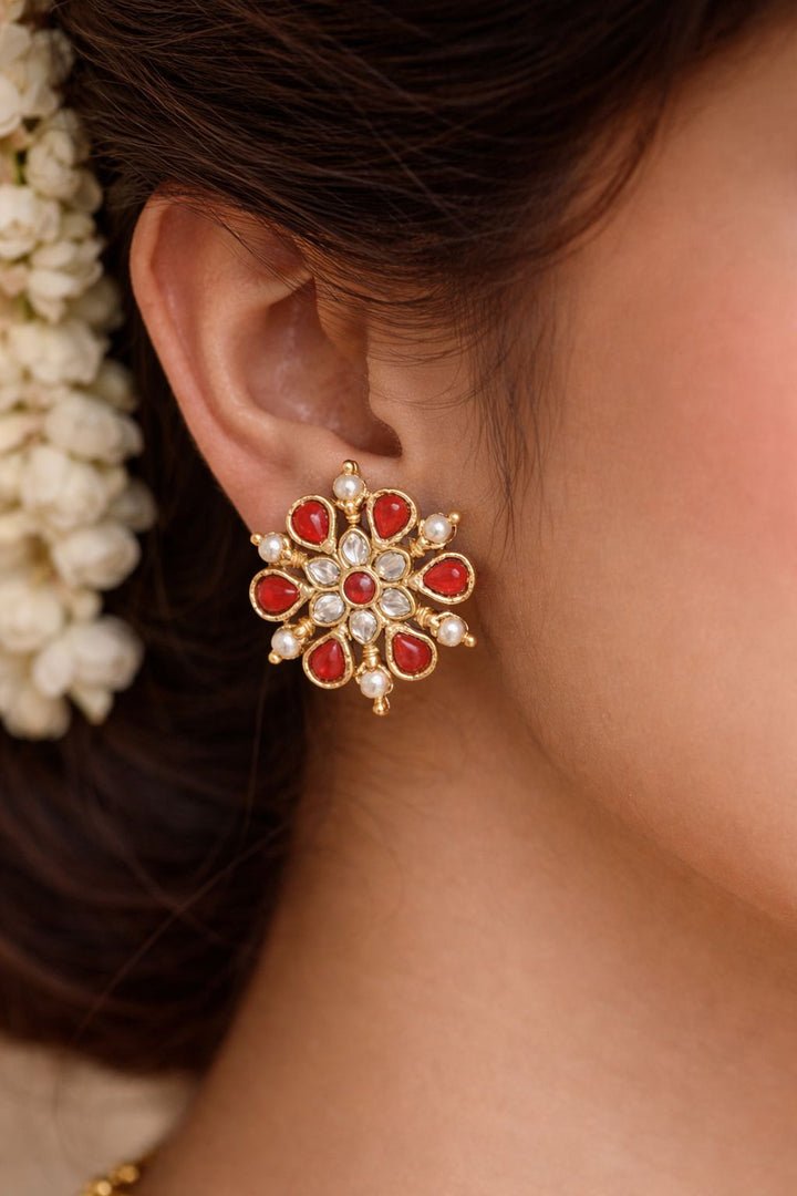 Close-up of an ear wearing a coral earring .