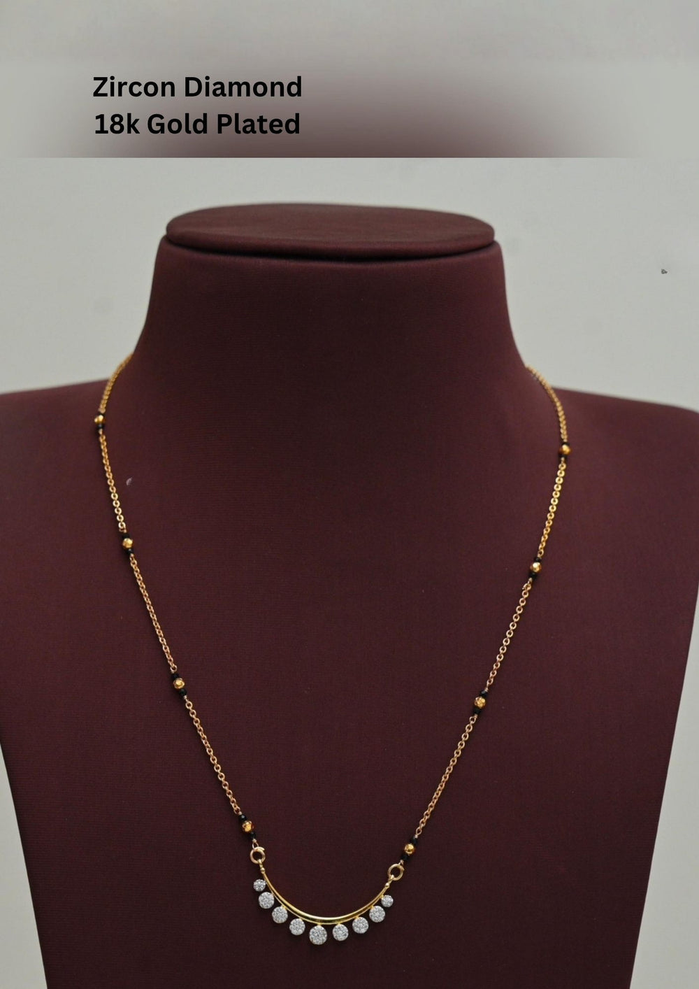Gold plated black beads mangalsutra featuring an elegant butterfly-inspired zircon centerpiece with delicate Crescent Shape  detailing. Lightweight and beautifully crafted for everyday elegance, festive occasions, and gifting.