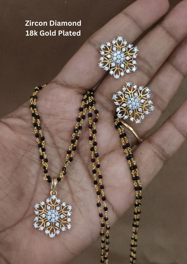 Elegant gold plated mangalsutra set featuring a floral zircon pendant with matching stud earrings. Crafted with a traditional black beaded chain and sparkling crystal stones for everyday elegance and festive wear. Perfect for daily wear, festive occasions and office wear.