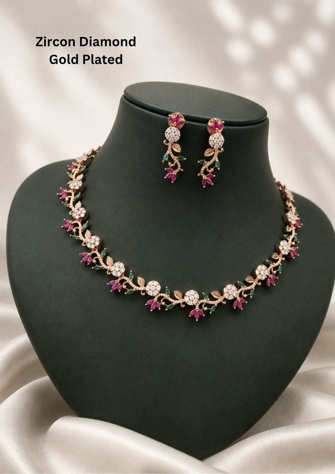 gold plated jewelry set featuring a delicate, creeping floral vine chain adorned with circular flower clusters of sparkling white pure zirconian diamonds, accented by marquise-cut pink ruby and green emerald stone leaves. The matching hanging earrings feature a floral top and a twisting vine drop decorated with matching pink and green stones. Perfect for weddings, parties, office wear, and festive celebrations with skin-friendly quality, comfortable fitting