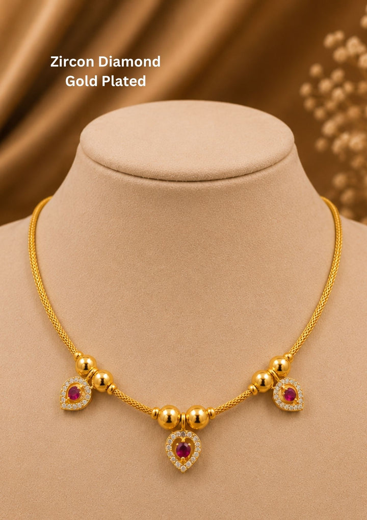 A sleek and minimalist 18k gold plated festive chain necklace featuring a delicate woven rope link. The chain is interspersed with small, polished gold spheres that lead to three hanging heart-shaped drop charms encrusted with clear white zircon diamonds and central vibrant ruby-red stones, perfect for weddings, dailywear, functions comes with anti fade color and skin friendly