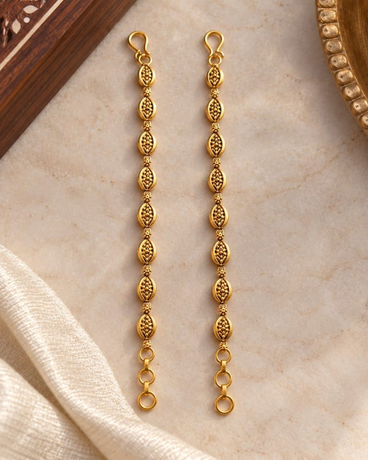 Gold plated traditional ear chains featuring intricate oval motifs, antique-style detailing, and decorative gold bead links.