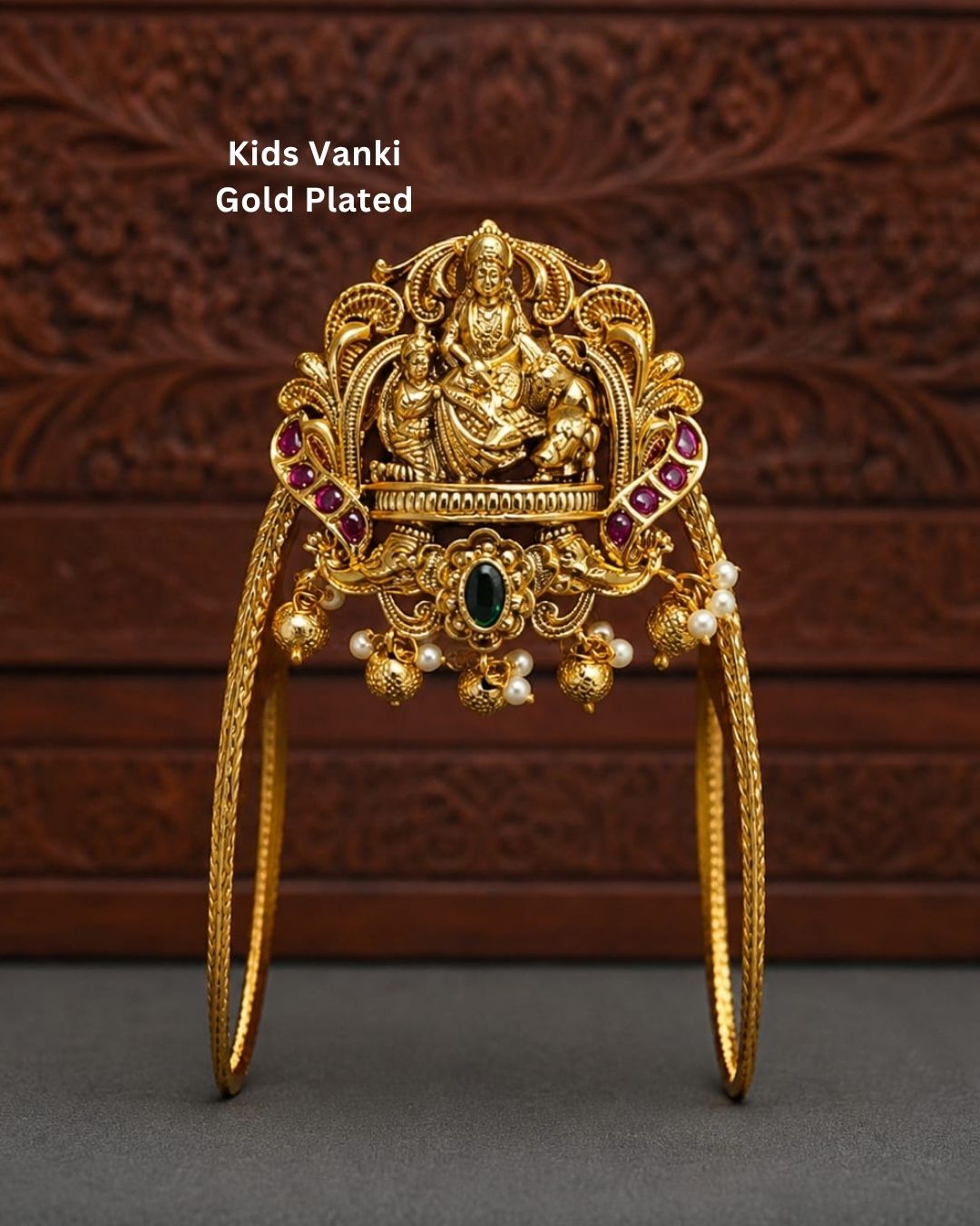 Beautiful gold plated kids vanki featuring an ornate Goddess Lakshmi design with vibrant ruby and green stone detailing, intricate traditional craftsmanship, and pearl embellishments. Perfect for traditional wear, festivals, weddings, classical dance, and special occasions.