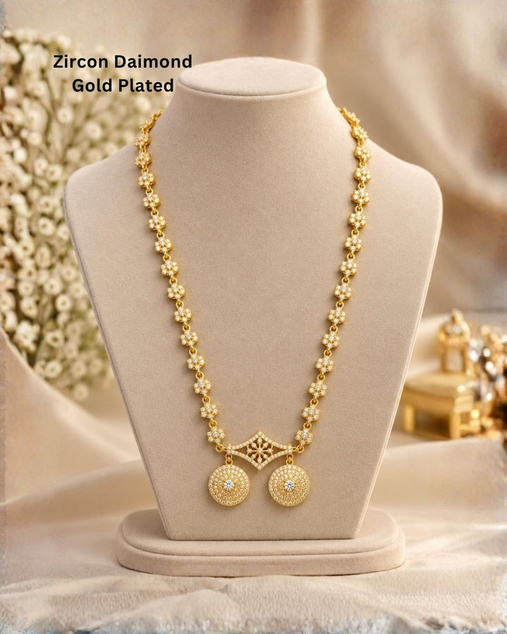 Elegant gold plated necklace with sparkling white stones, floral motifs, and two round dangling pendants.