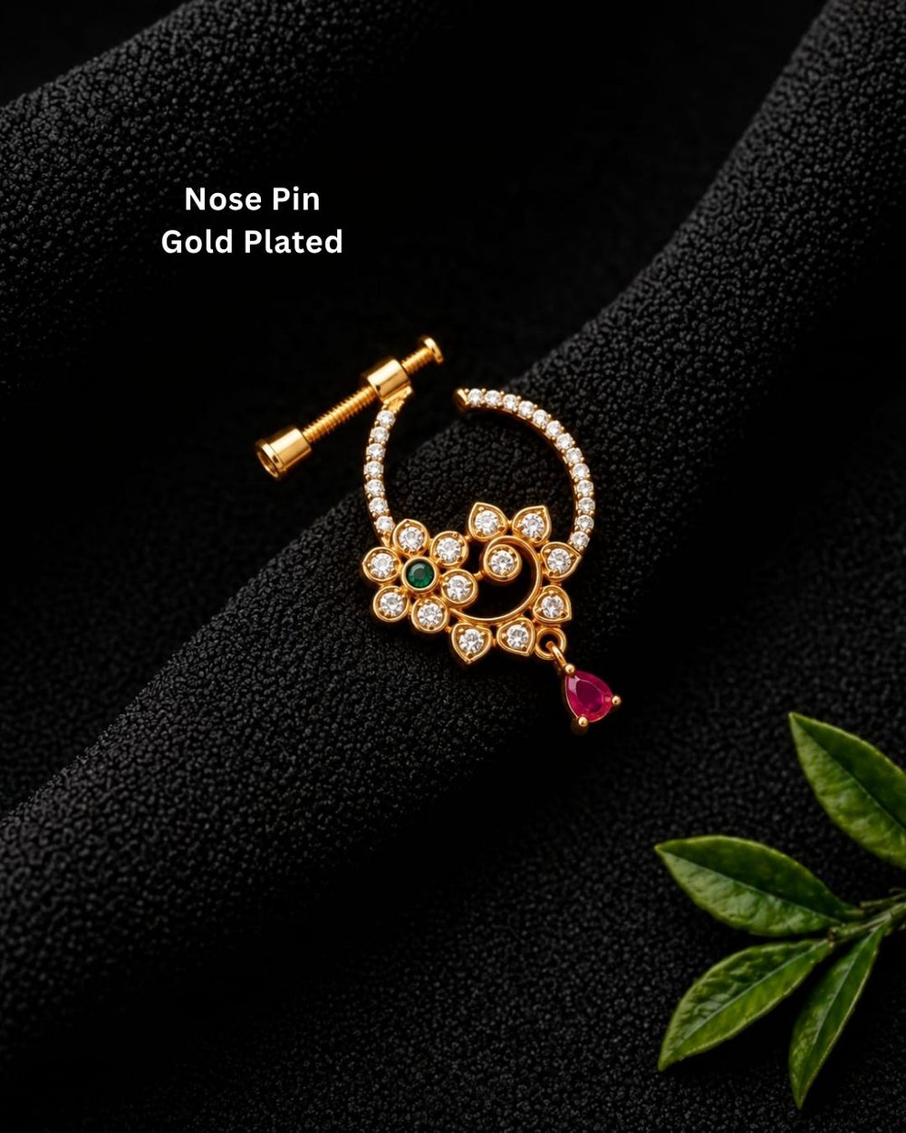 Traditional gold plated floral nose pin with white CZ detailing, a green stone center, and a pink teardrop pendant.