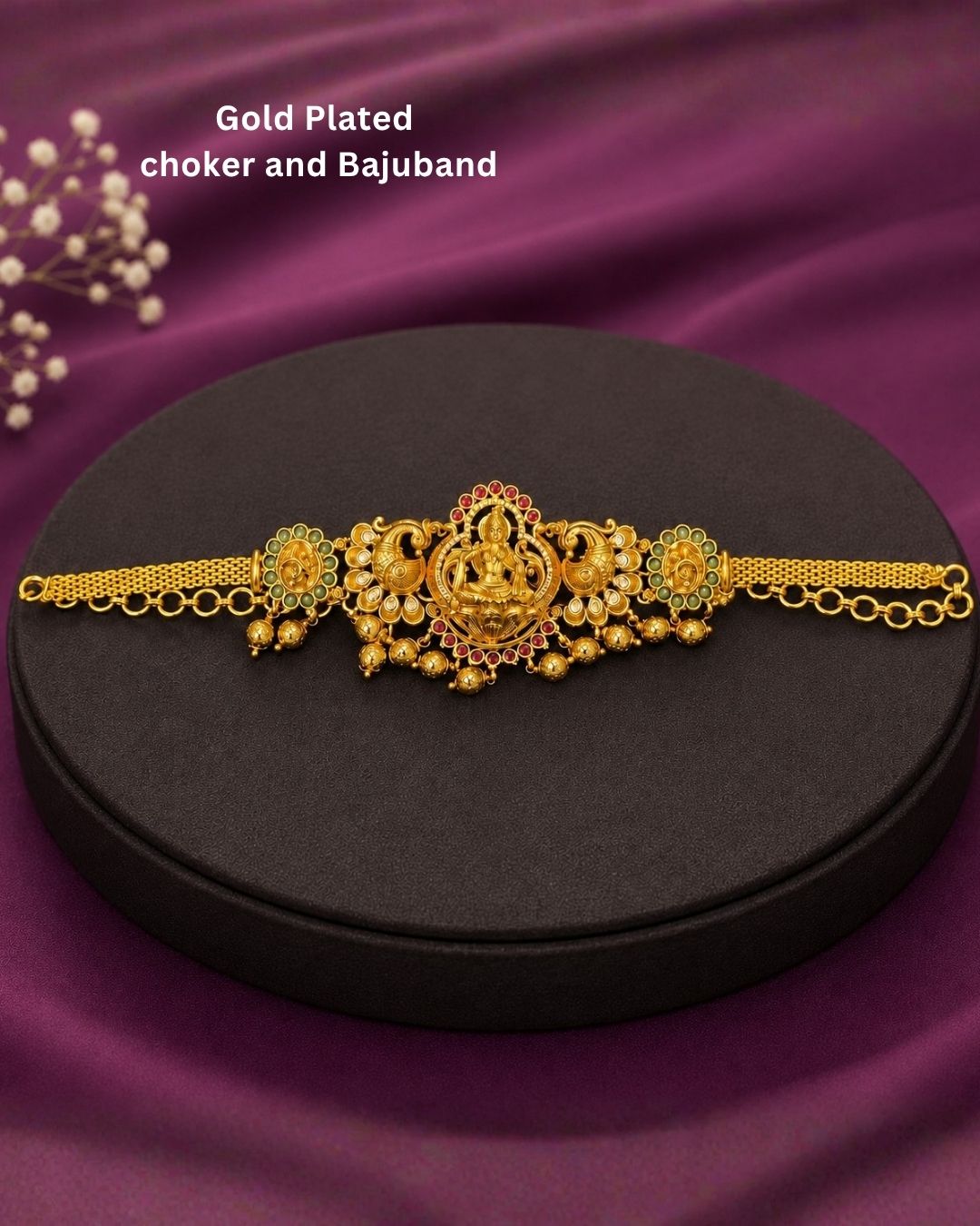 Beautiful traditional 2 in 1 gold plated choker and bajuband set featuring a detailed Goddess Lakshmi centerpiece, ornate peacock motifs, sparkling white stones, red and green accents and elegant gold bead drops.