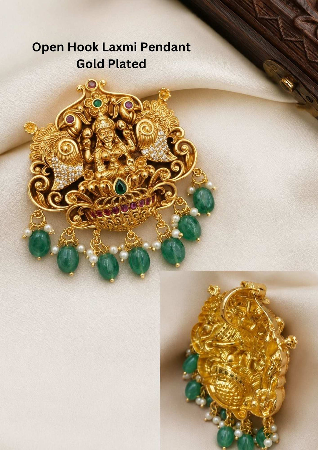 A highly detailed antique gold plated temple pendant featuring a secure open-hook backing system for easy chain attachment. The front depicts a beautiful carving of Goddess Lakshmi seated on a lotus, flanked by two elaborate fan-tailed peacocks adorned with white stones. The bottom rim is accented with pink rubies and a row of hanging oval green emerald beads.