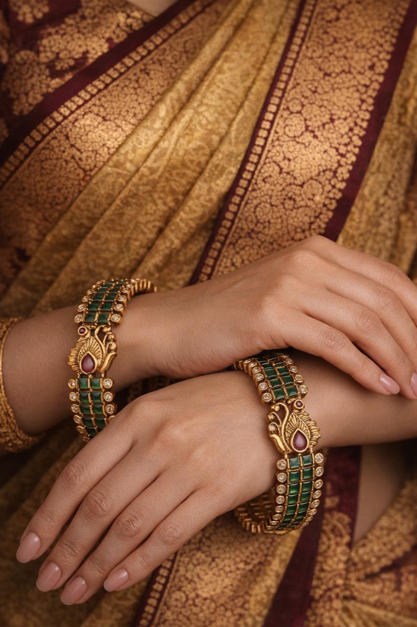 Close-up of hands wearing gold bangles with green kempu peacock 