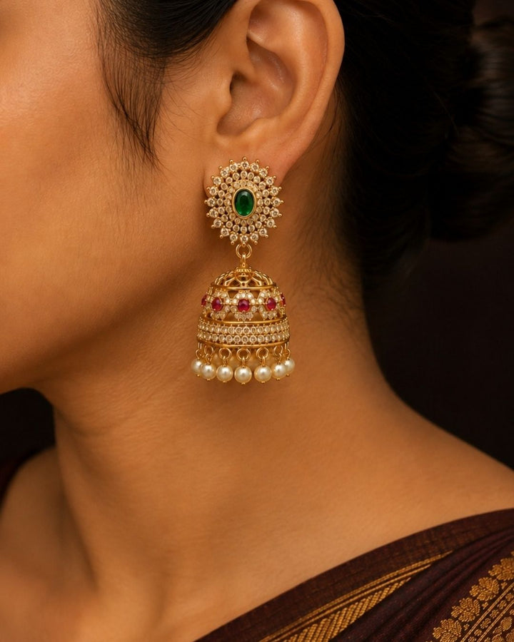 Traditional gold plated bangle and jhumka earrings set featuring CZ stones, green gemstones, pink accents, pearl hangings, and a luxurious velvet presentation for festive occasions.