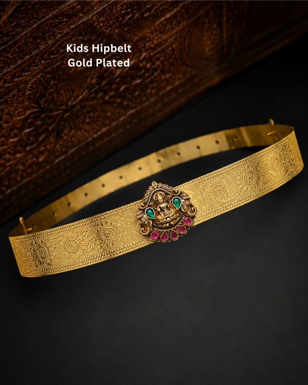 Beautiful gold plated kid’s hip belt featuring a wide engraved band with a traditional Lakshmi centerpiece decorated with ruby and green stones. Perfect for traditional wear, weddings, festive occasions, cultural events, parties, and gifting.