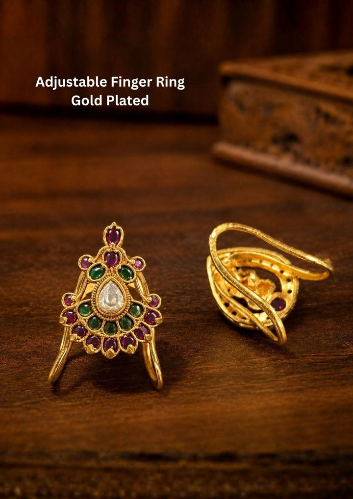 Traditional gold plated adjustable finger ring featuring an intricate antique-inspired design adorned with ruby pink and emerald green kemp stones. The centerpiece showcases a pear-shaped white kundan stone surrounded by circular stone detailing in a graceful temple jewelry pattern. The adjustable open-back design ensures a comfortable fit while adding an elegant ethnic touch suitable for weddings, festivals and cultural occasions.