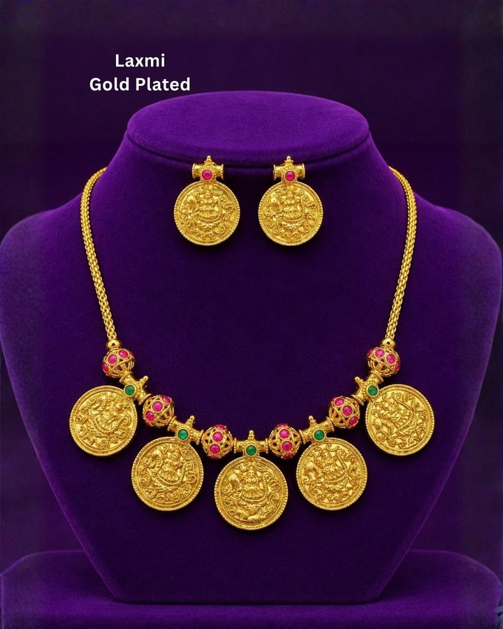 Traditional gold plated designer necklace and earrings set featuring multiple Goddess Lakshmi coin pendants, intricate temple-inspired detailing, ruby and green stone accents, and matching Lakshmi coin earrings, perfect for festive, wedding, and traditional occasions.