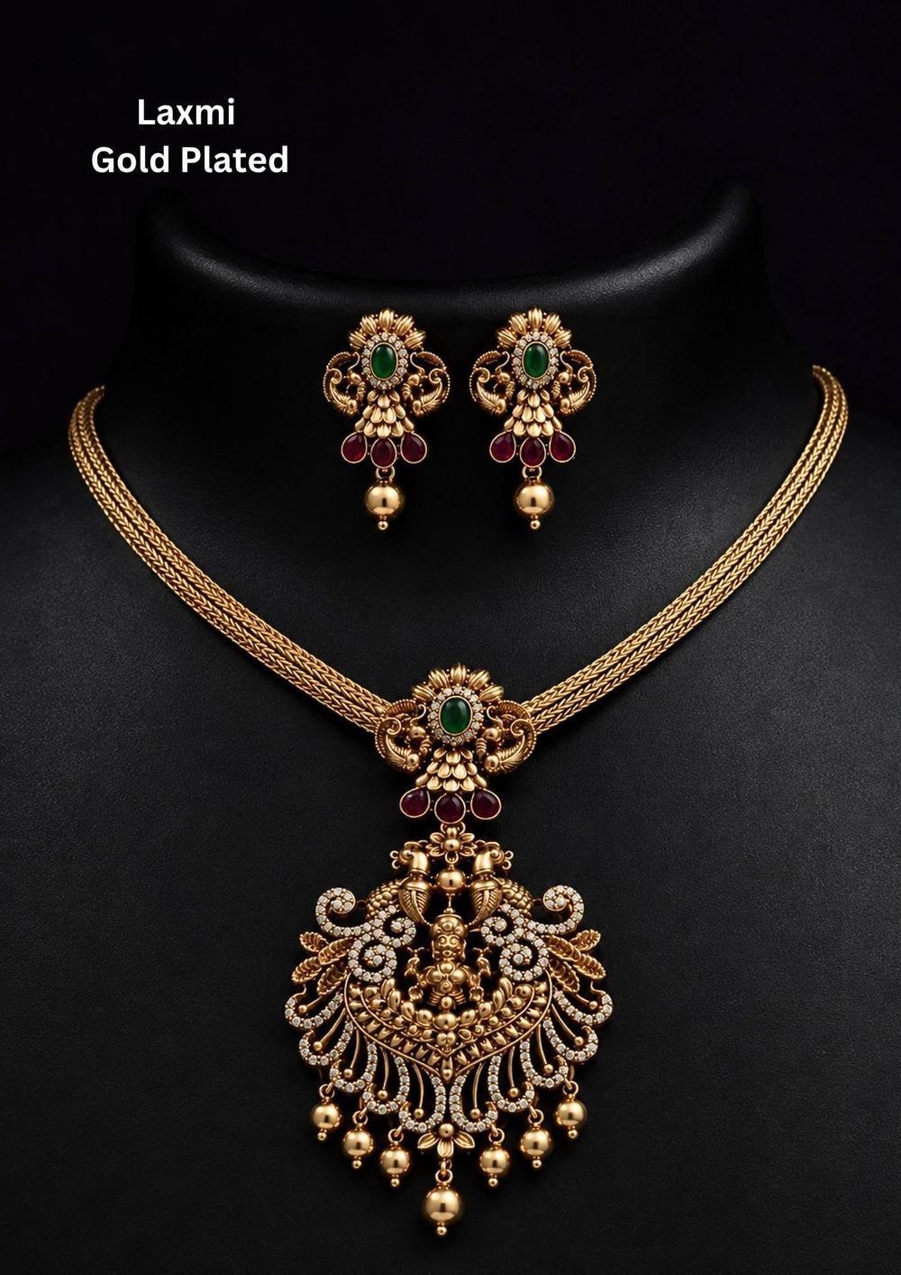 Gold-plated necklace and earrings set and in image clearly shown how it looks matching earrings, green stones, zircon detailing, and pearl drops. The temple jewelry design features Goddess Laxmi pendant with floral traditional patterns and antique gold finish. The layered necklace and matching earrings give a grand and elegant ethnic jewelry appearance. Comfortable, skin-friendly, sweat proof, and perfect for weddings, festivals, sarees, and family functions.