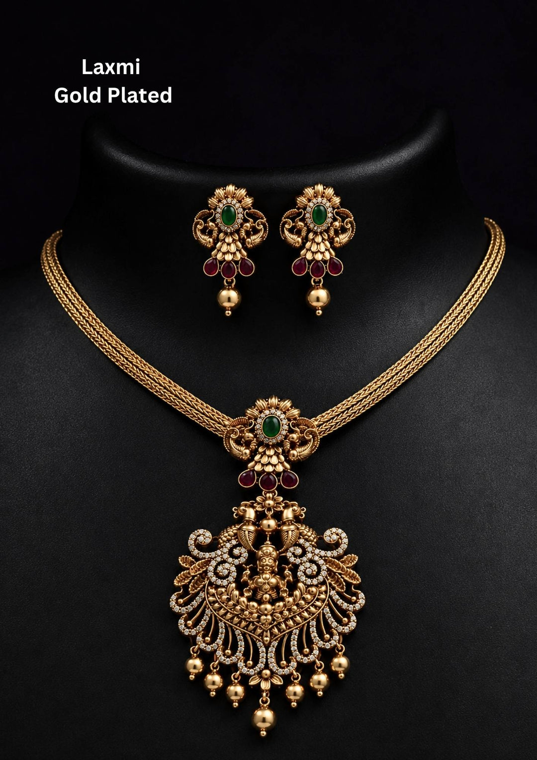 Gold-plated necklace and earrings set and in image clearly shown how it looks matching earrings, green stones, zircon detailing, and pearl drops. The temple jewelry design features Goddess Laxmi pendant with floral traditional patterns and antique gold finish. The layered necklace and matching earrings give a grand and elegant ethnic jewelry appearance. Comfortable, skin-friendly, sweat proof, and perfect for weddings, festivals, sarees, and family functions.