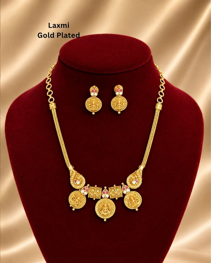 Traditional gold plated designer necklace and earrings set featuring multiple Goddess Lakshmi coin motifs, intricate temple-inspired detailing, ruby-colored stone accents, and matching decorative earrings, perfect for festive, wedding, and traditional occasions.