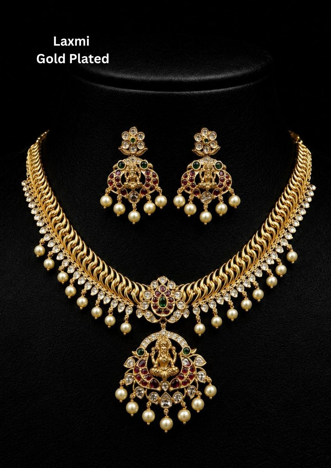 Gold Plated Laxmi Jadau Kundan Necklace Set is designed with green and red stones with white stones attached to pearl drop beads and the two rows of a chain is designed in curve chain pattern combined to a flower shape designed and comes with the locked designed with laxmi devi short necklace and this set comes with the matching earrings . Perfect for poojas, festivals, weddings and its anti fade color and sweat proof.