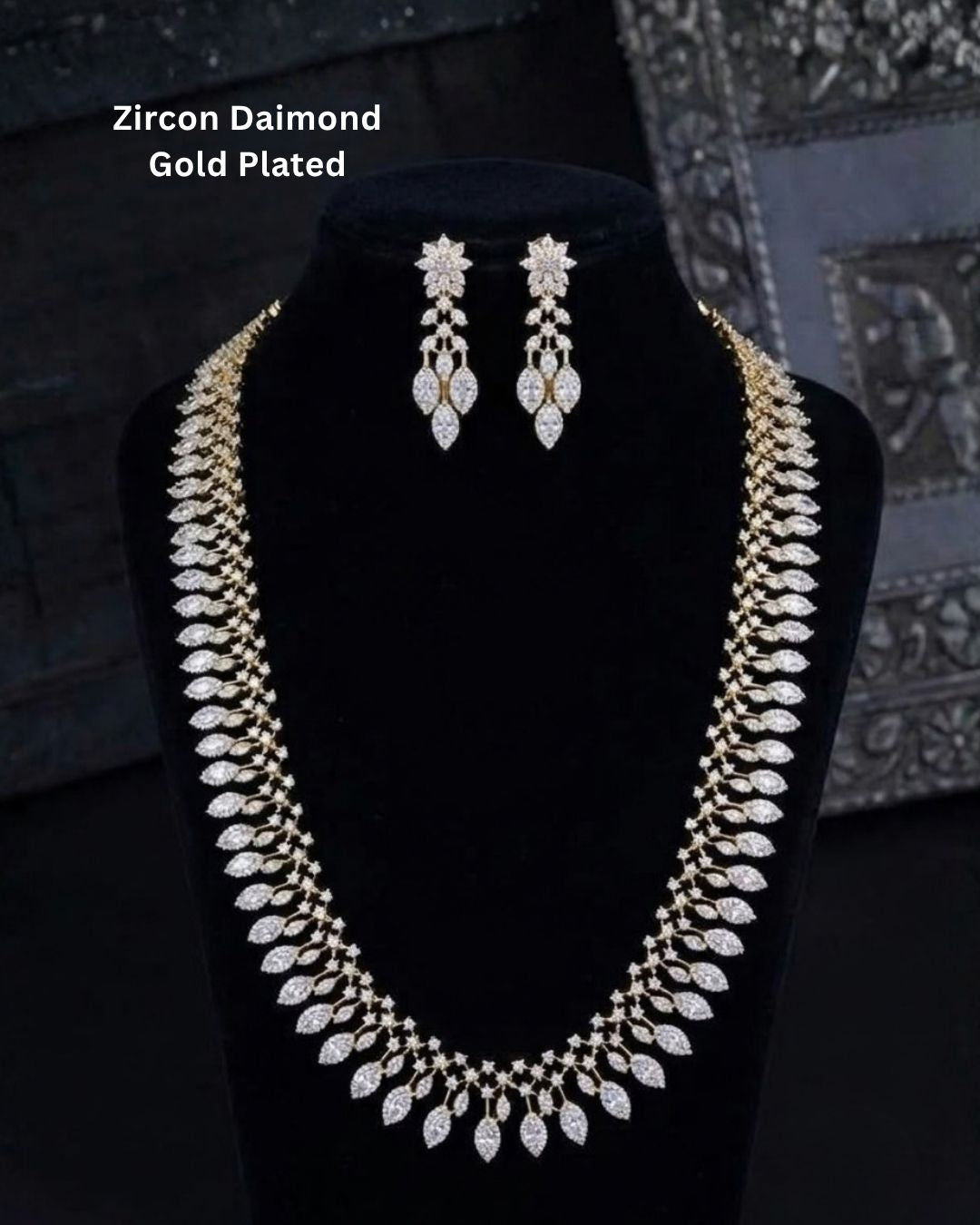 Designer gold plated long necklace and matching earrings featuring intricate leaf motifs embellished with sparkling white stones, perfect for festive, wedding, and traditional occasions.