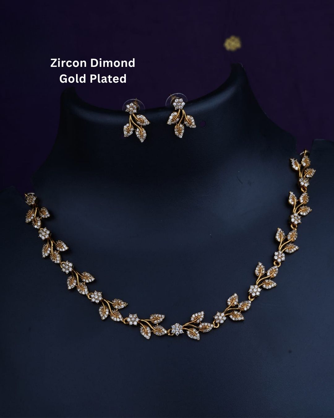 Designer gold plated necklace and earrings set featuring an elegant arrangement of leaf and floral motifs embellished with sparkling white stones, perfect for festive, wedding, and elegant occasions.