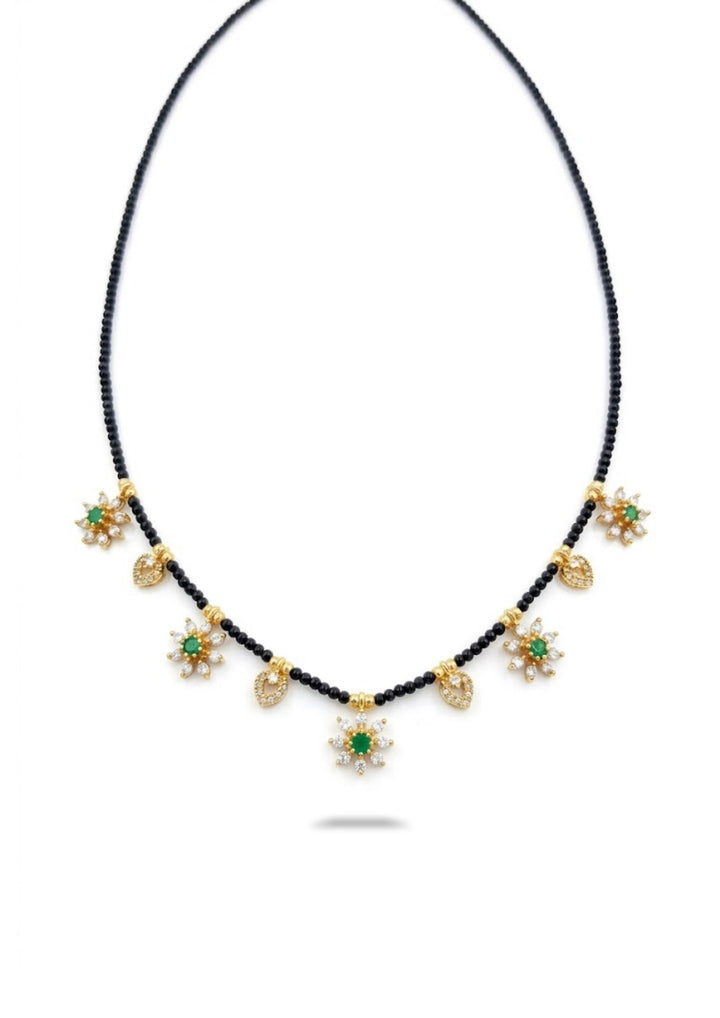 Necklace with gold and green star-shaped pendants on a white background
