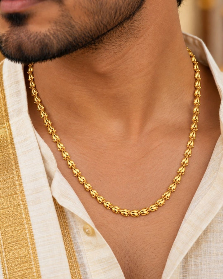 Gold plated men’s chain displayed in hand, showcasing its decorative leaf-shaped links and shiny finish.