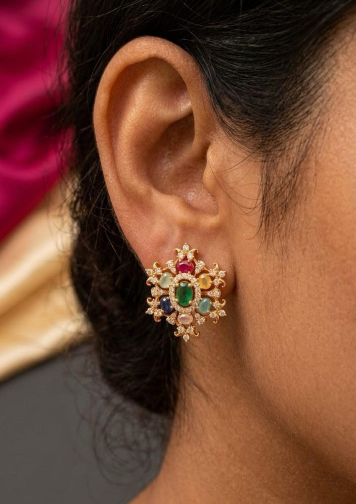 Close-up of an ear wearing a navarathna studs and close see the detailing of the studs with shine and  classy look can be used for dailyware, functional ware and for gifting 
