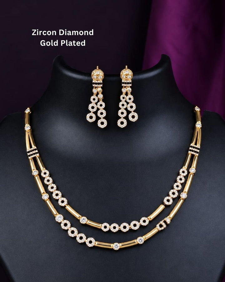 Stylish gold plated necklace set featuring layered gold-tone chains, sparkling circular stone embellishments, and matching dangling earrings, perfect for festive, party, and traditional occasions.