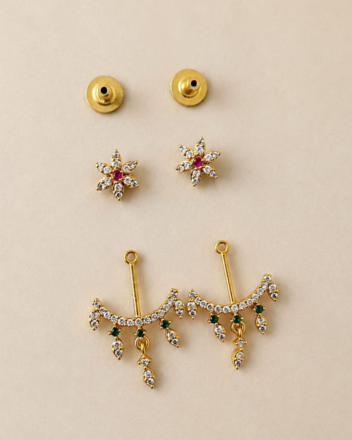 Beautiful gold plated designer dangler earrings featuring intricate floral detailing, sparkling CZ stones, pink and green accents, and delicate hanging drops. Perfect for festive occasions, parties, traditional wear, and gifting.