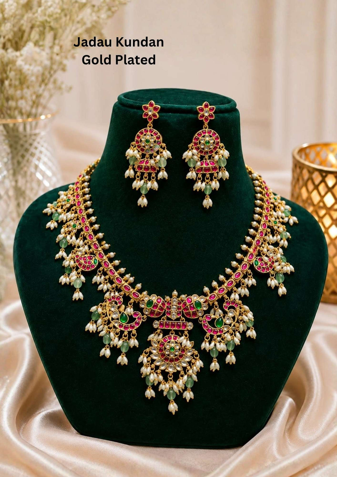 Elegant gold plated Kundan necklace set adorned with pink ruby stones, green accents, floral motifs, pearl drops, and matching earrings for festive occasions.