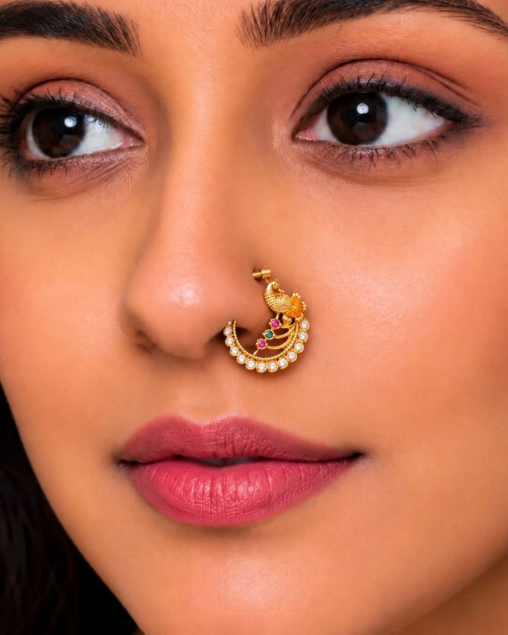 Traditional gold plated peacock-inspired nose pin with white CZ stones and pink and green accents, featuring a screw-back design.