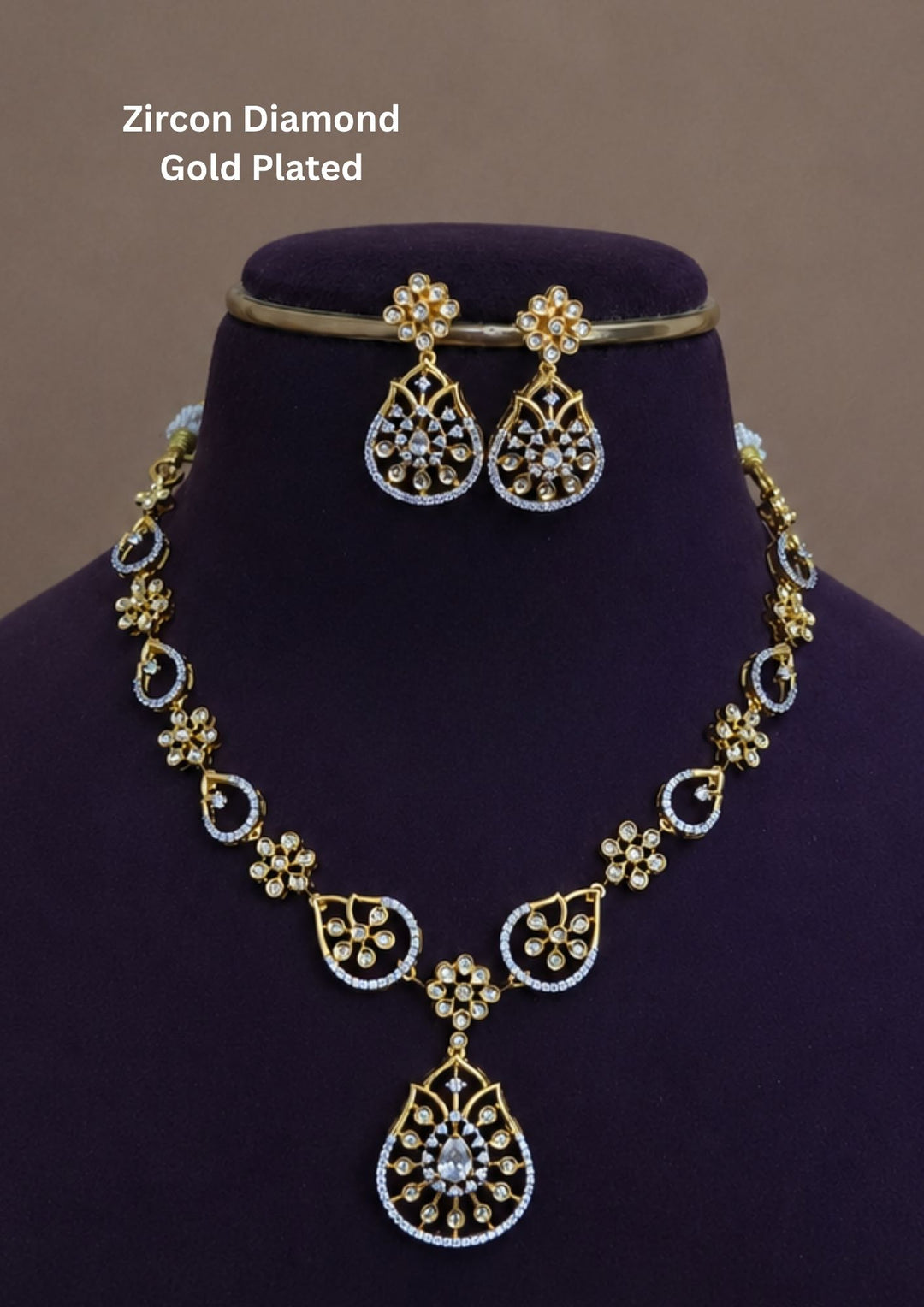 Premium gold plated pendant necklace set crafted with shimmering zircon stones, floral detailing, and matching earrings for bridal, festive, and party wear jewellery collections.