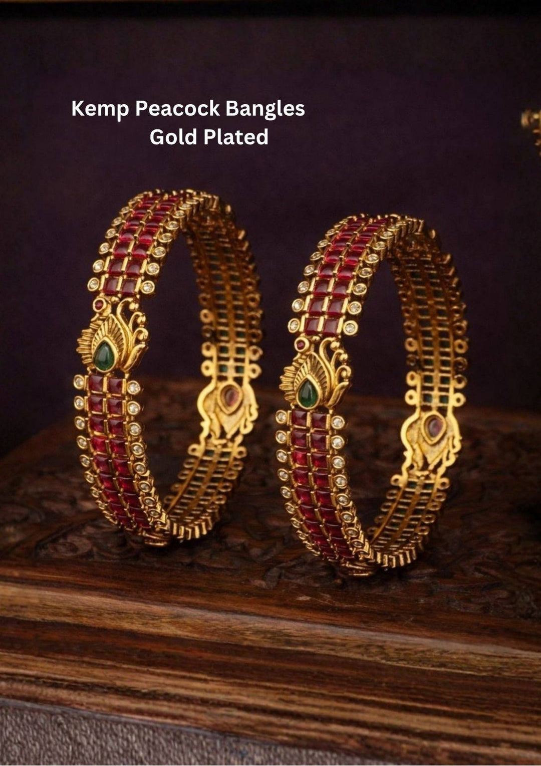 Premium gold-plated real Kemp peacock bangles designed with multiple rows of square-cut red Kemp stones, with white crystal borders, and an ornate golden peacock design centered with a water drop green stone. It is lightweight, skin-friendly, and anti-fade bangles are perfect for poojas, festive wear, and dailywear.