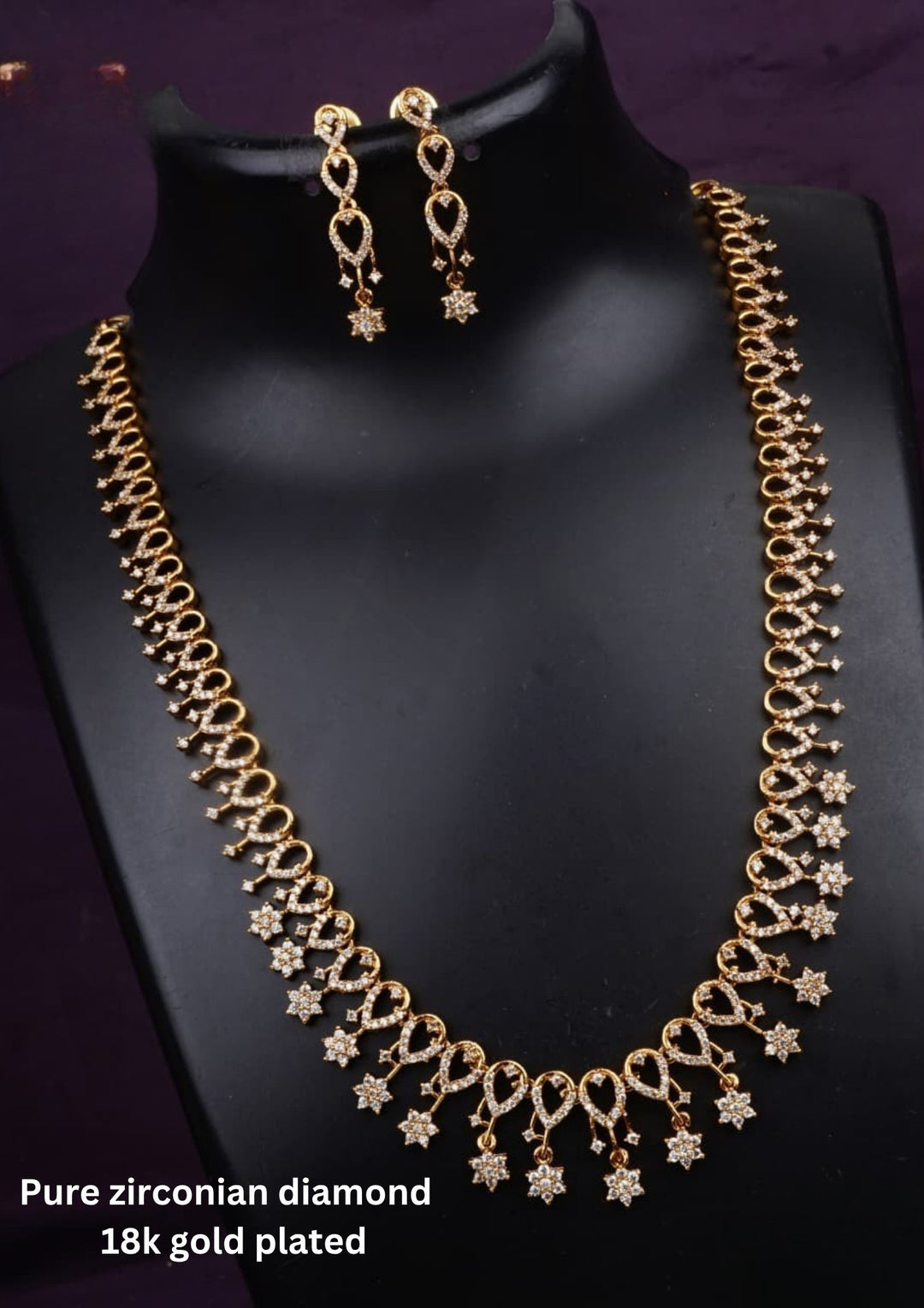 Traditional gold plated necklace set for women featuring ruby-red and emerald-green stones, sparkling accents, intricate teardrop patterns, and matching earrings, perfect for festive and ethnic wear.