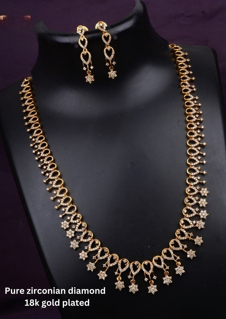 Traditional gold plated necklace set for women featuring ruby-red and emerald-green stones, sparkling accents, intricate teardrop patterns, and matching earrings, perfect for festive and ethnic wear.