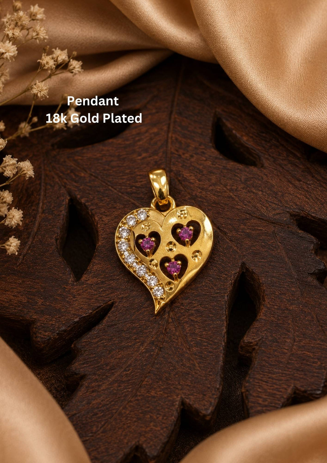 The main heart features an asymmetric, sweeping border on the left side encrusted with a row of small, clear sparkling stones. Inside the main heart, there are three cut-out heart shapes, each Nesting a vibrant, pinkish-red stone (resembling rubies or pink crystals) at its center.