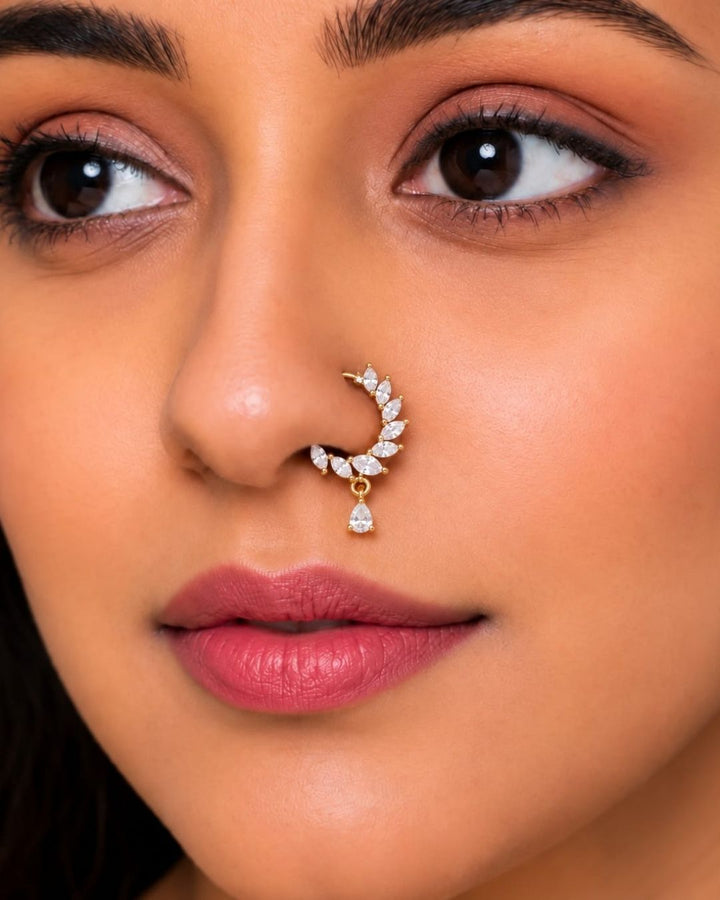 Minimal gold plated crescent nose pin with brilliant white CZ stones and a delicate teardrop stone accent.
