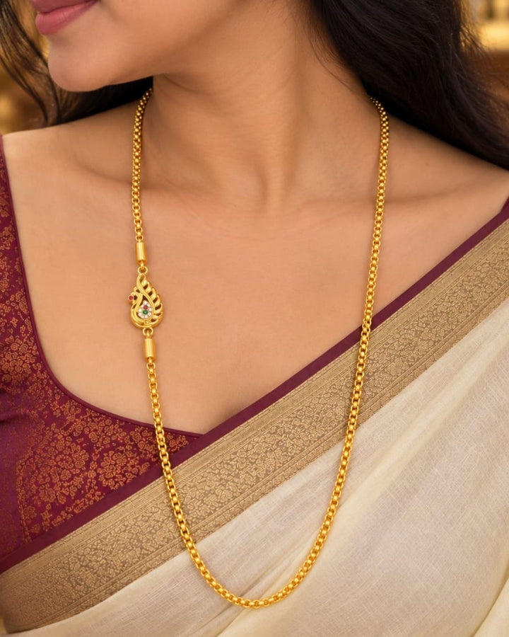 Elegant gold plated thalli chain displayed on beige silk with a carved wooden jewellery box, featuring a simple chain and a detailed ornamental clasp.