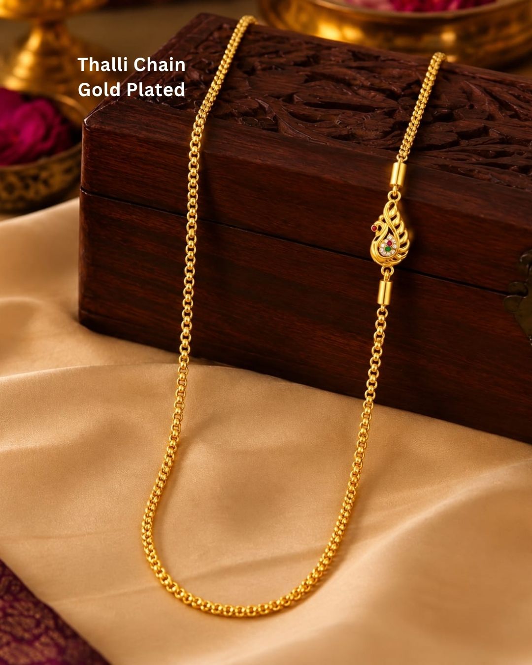 Elegant gold plated thalli chain displayed on beige silk with a carved wooden jewellery box, featuring a simple chain and a detailed ornamental clasp.